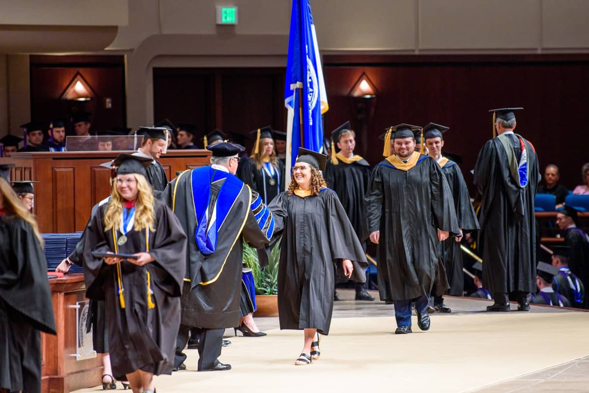 PCC Graduates walk across the stage at PCC Commencement ceremony.