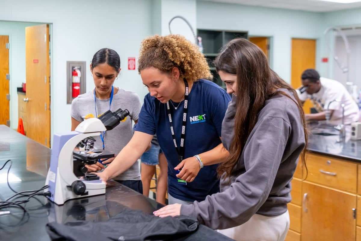 Next team leader helps campers in a parasitology lab