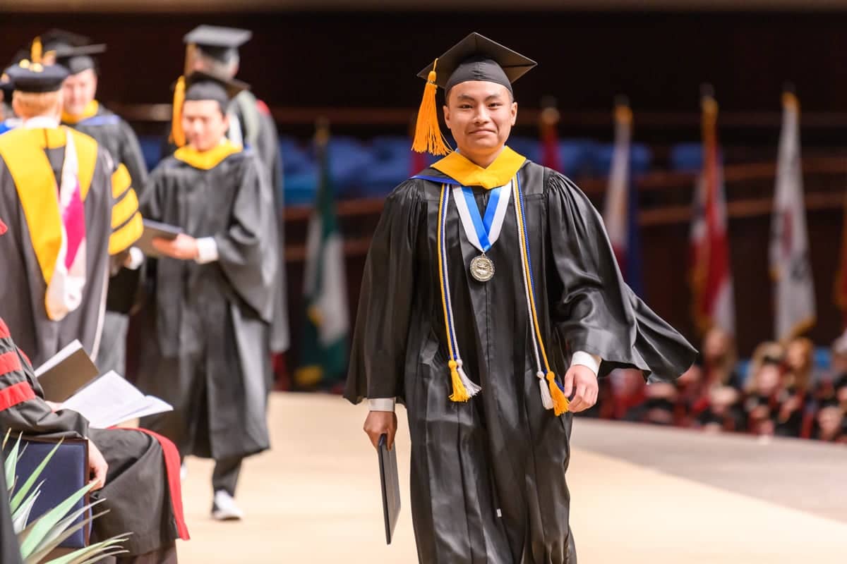 PCC Graduate walks across the stage during Commencement