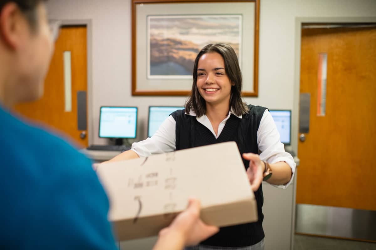 Post Office Worker Handing Package to Customer