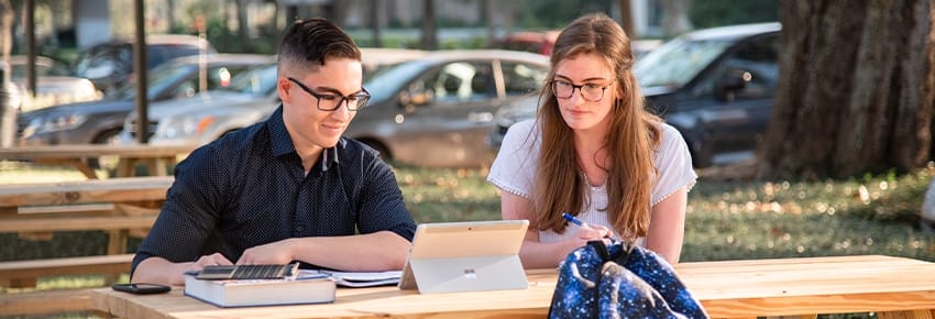 Two PCC students studying at a picnic table