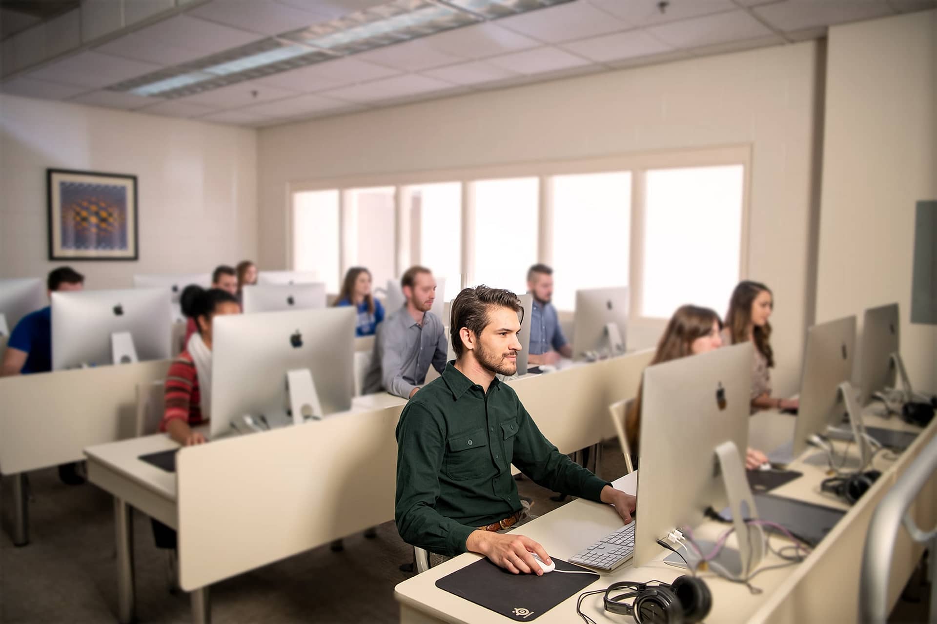 Interterm students sitting at computers in a computer lab.