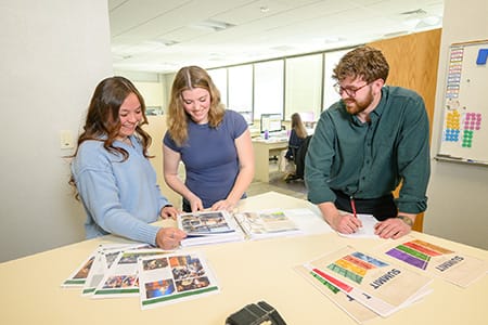 Students review pages of the Summit yearbook