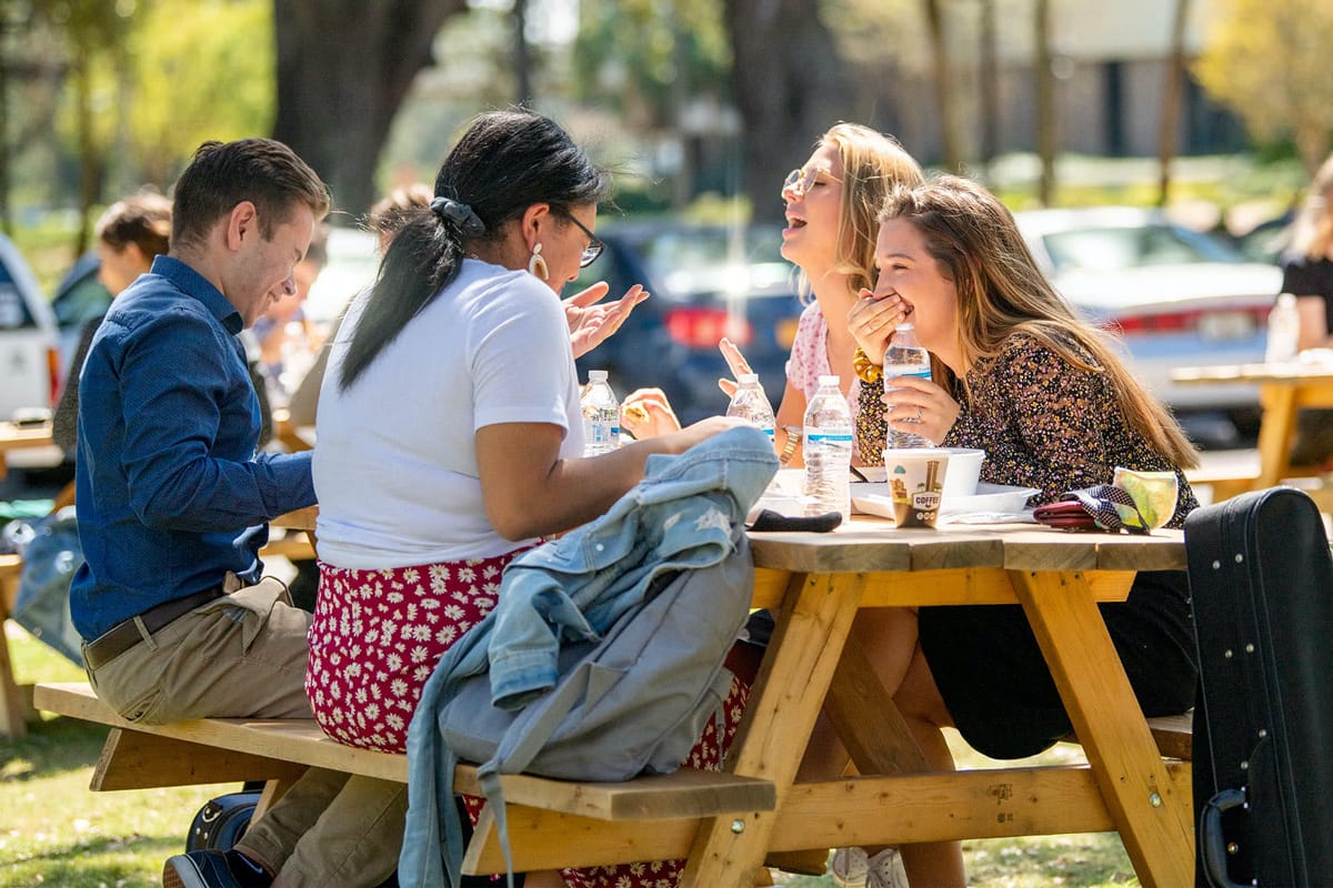 Group of PCC students eating lunch at a picnic table