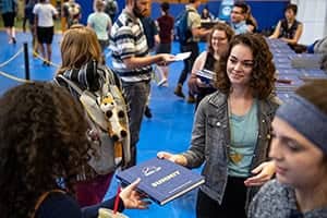 Summit staff hands out books to waiting students