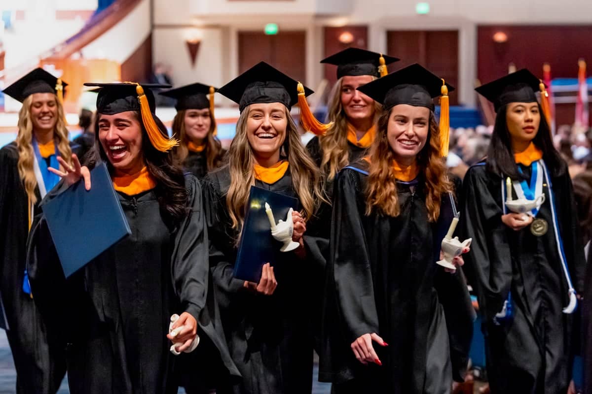 2024 Nursing Graduates walk with their lamps during Commencement