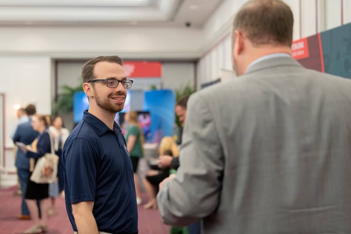 Male student talks to a recruiter at PCC's Educator Recruitment event