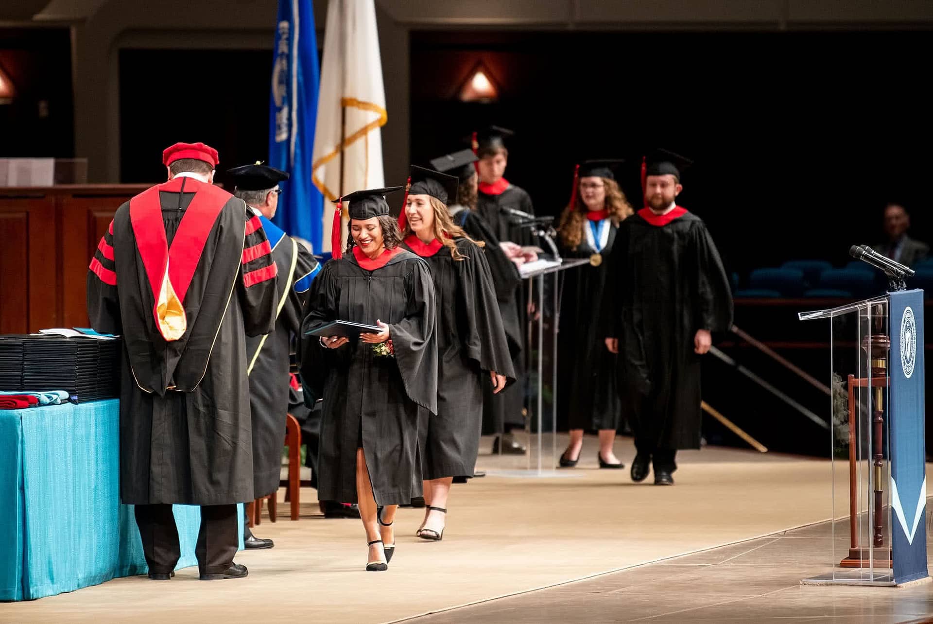 Graduates walking across Crowne Centre stage