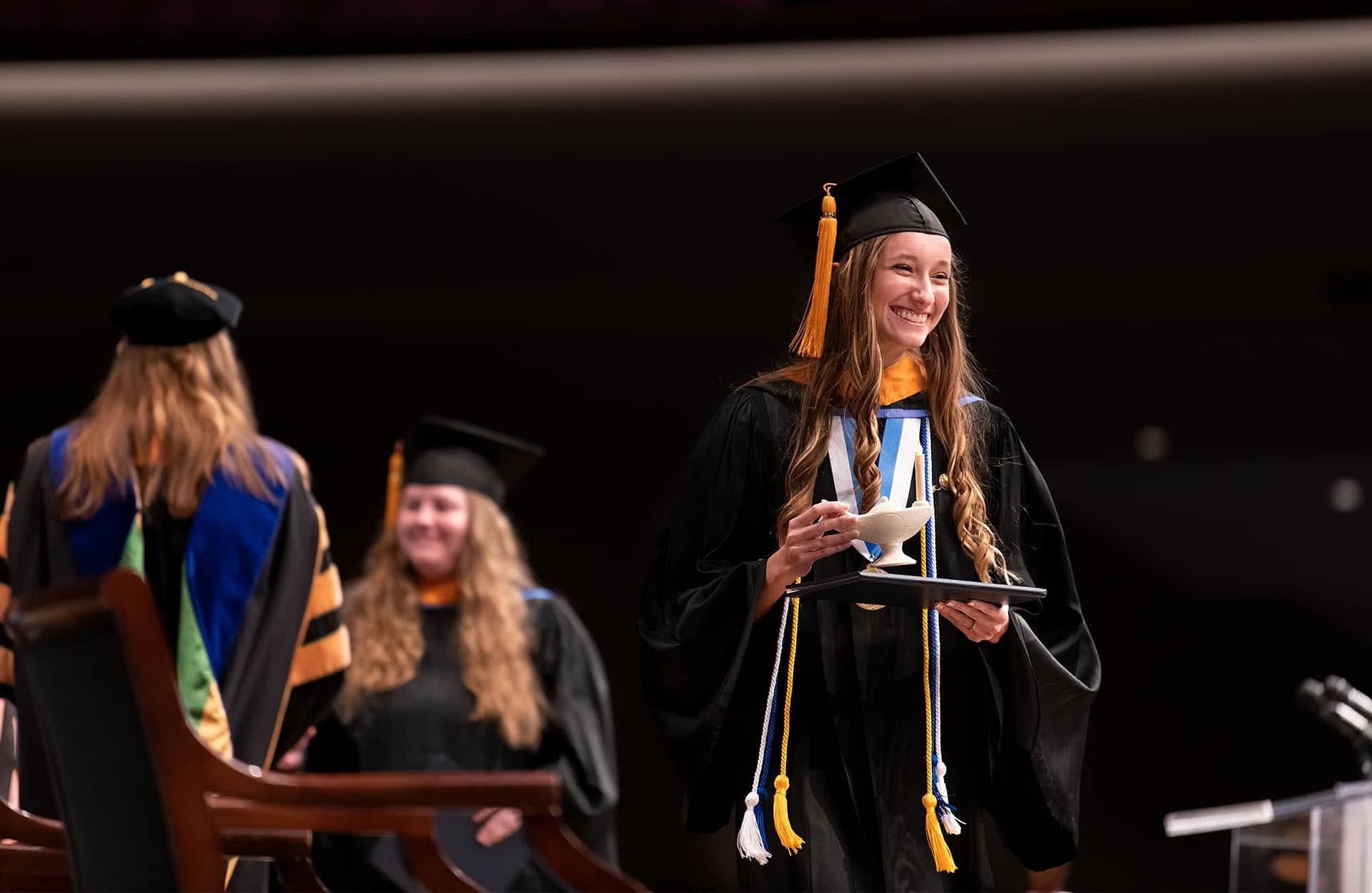 Female nursing graduate walking across stage